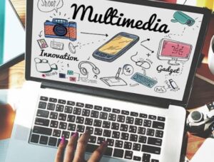 A person using a laptop with the screen displaying the word "Multimedia" surrounded by colorful illustrations of a camera, smartphone, computer monitor, headphones, keyboard, and other tech-related icons, along with the words "Innovation" and "Gadget."